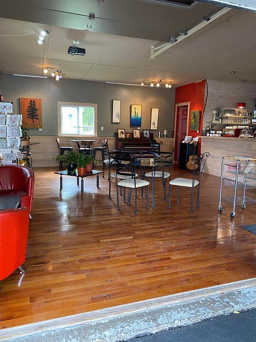 L'intérieur du café : toiles d'artistes, piano et fauteuils rouges